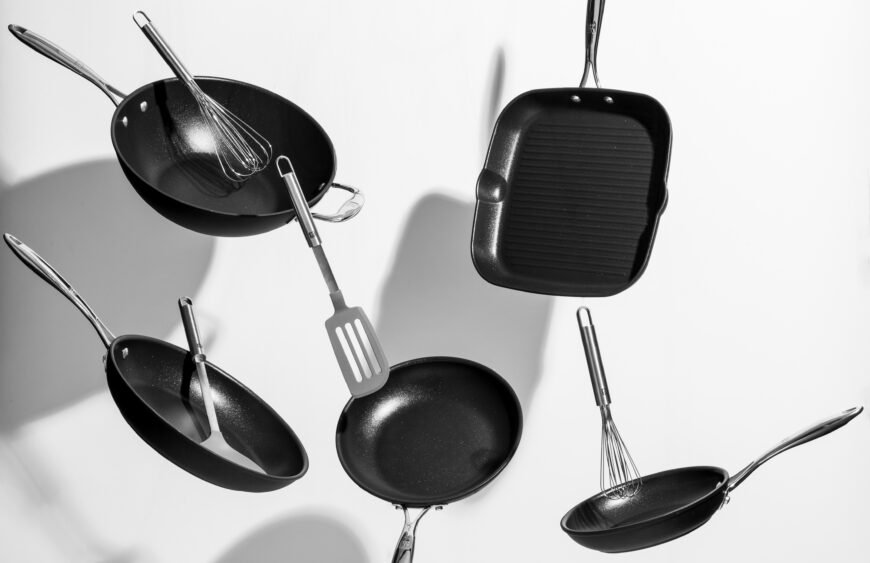 Interesting shot of trendy black kitchen utensils dancing on white background