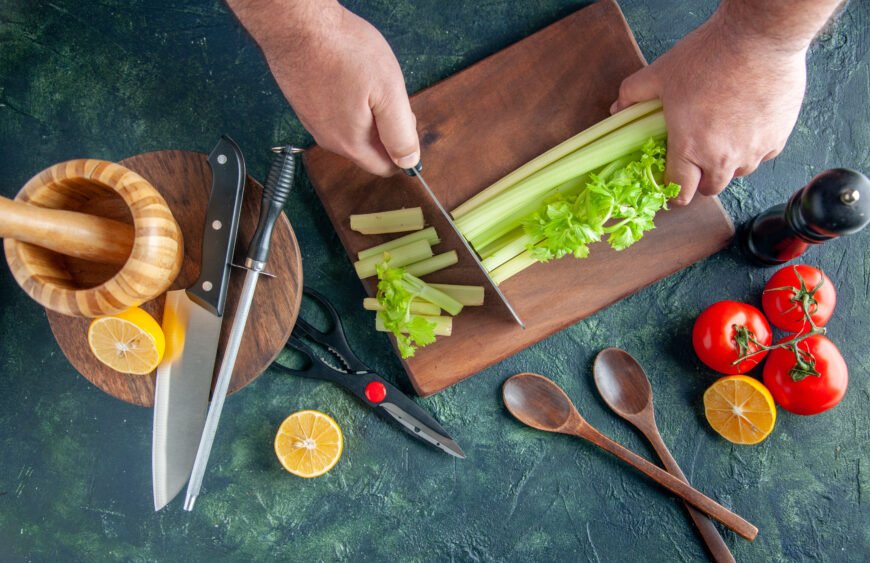 top-view-male-cook-cutting-celery-dark-table-salad-diet-meal-color-photo-food-health